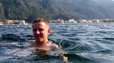 Young man swimming in the sea Stock Footage 30556635