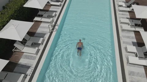 The young man swims across the pool. Stock Footage 153888859