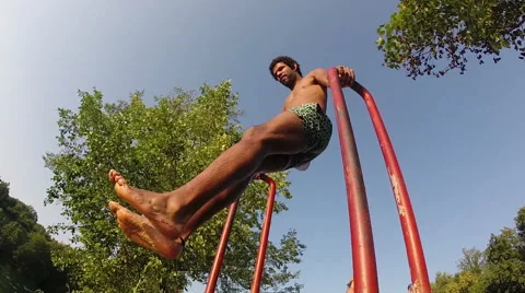 Young man swinging and jumping into river Stock Footage 59559178