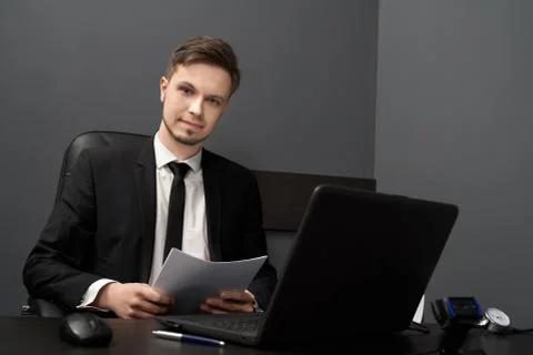 Young man at table with computer polygraph in grey room. Foto stock