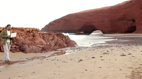 Young man with tablet computer on beautiful Legzira beach 스톡 동영상 10892108