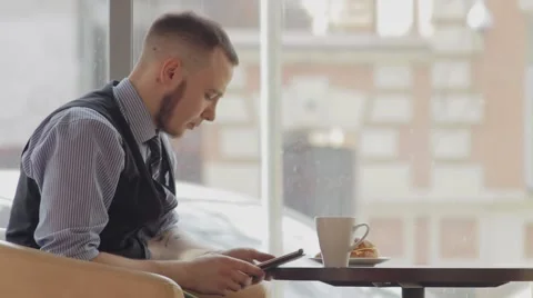 Young man with tablet computer drinking coffee in cafe Vídeos de archivo 49894202