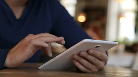 Young man with tablet computer drinking coffee in cafe Stock Footage 67862463