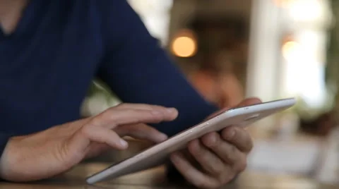 Young man with tablet computer drinking coffee in cafe Stock Footage 67862485
