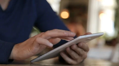 Young man with tablet computer drinking coffee in cafe Stock Footage 67862513