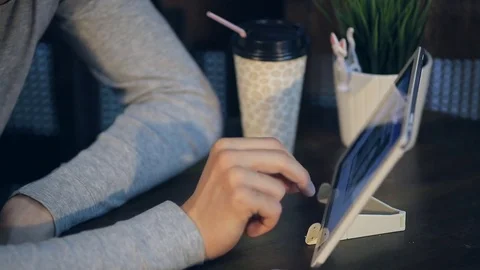Young man with tablet computer drinking coffee in cafe Stock Footage 74775524
