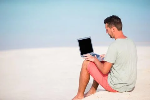 Young man with tablet computer during tropical beach vacation Stock Photos