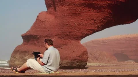 Young man with tablet computer on Legzira beach Видео 10892250