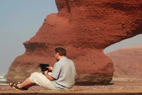 Young man with tablet computer on Legzira beach Видео 10892383