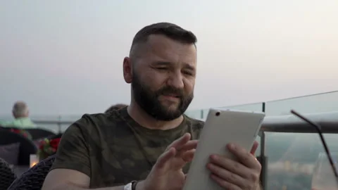 Young man with tablet computer at luxury rooftop restaurant Stock Footage 159065572