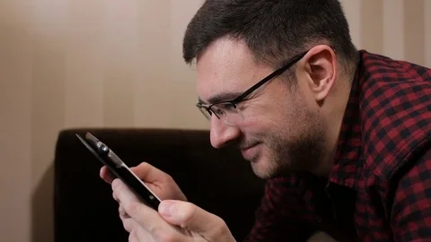 Young man with tablet computer lying on sofa read funny news Video stock 72342363