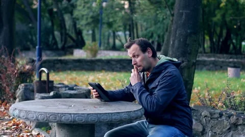 Young man with tablet computer in the park Stock Footage 8916463