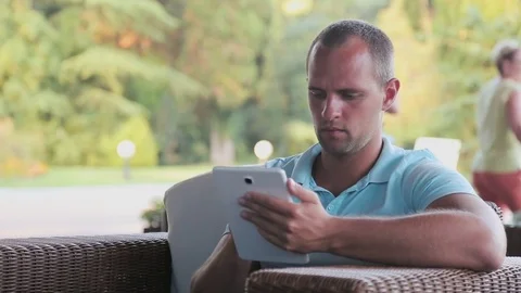 Young man with tablet computer sitting by the city street. Stock-Footage 81654840