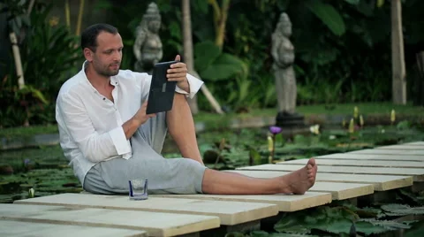 Young man with tablet in the exotic garden HD Stock Footage 41055033