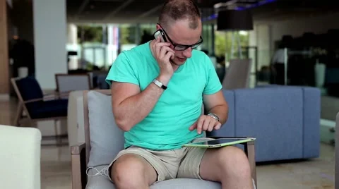 Young man with tablet pc and smartphone in hotel lobby. Stock Footage 53606812