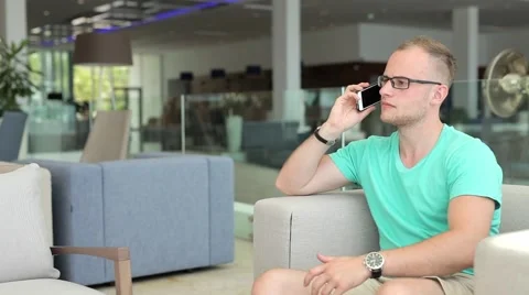 Young man with tablet pc and smartphone in hotel lobby. Stock-Footage 54543874