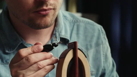 Young man tailor cutting thread on stitch on leather close-up, and burning Stock Footage 157374699