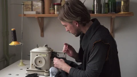 Young man tailor sewing fur on furrier machine Video stock 101369087