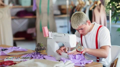 Young man tailor sews clothes on a sewing machine in the workshop. Fashion Stock Footage 330411378