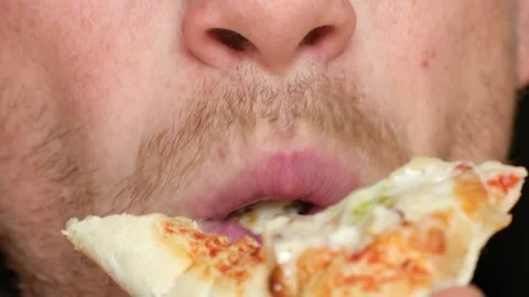 Young man takes bite from pizza with pleasure slow motion Stock-Footage 277956846