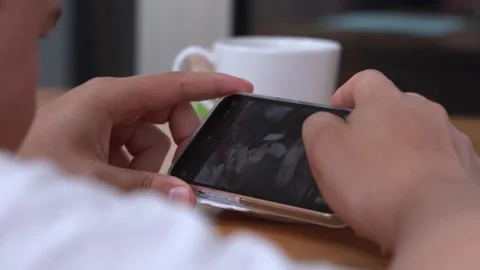 A young man takes a close-up photo on a phone with a macro lens of a cake with Stock Footage 186228053