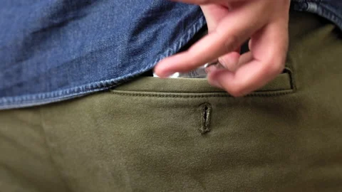 A young man takes a condom from the back pocket of his pants and is ready to use Stock Footage 161233551