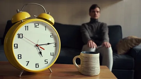 Young man takes the cup of tea off the shelf drinking sitting on couch Stock Footage 80814095