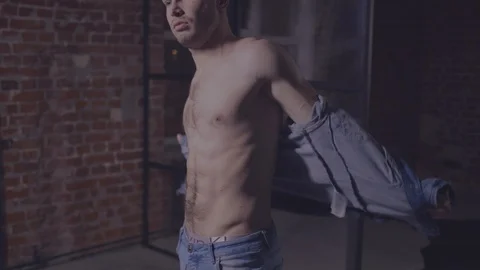 Young man takes off his jacket Stock Footage 104097575