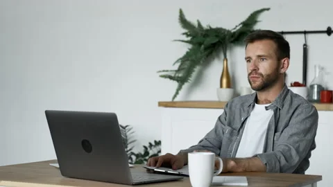 A Young Man Takes Notes on Paper, A Freelancer Works At Home Video stock 157053519