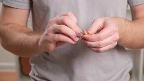 A young man takes out a tablet, pill from a blister pack. The concept of health Stock Footage 236921384