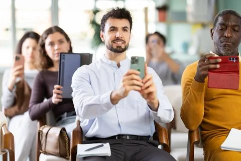 Young man takes photo or scans QR code with mobile phone Stock Photos