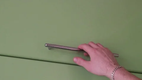 The young man takes puts a plate in the utensil drawer Stock-Footage 73348360