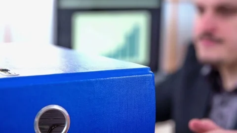 Young man is taking a blue folder from the top Stock Footage