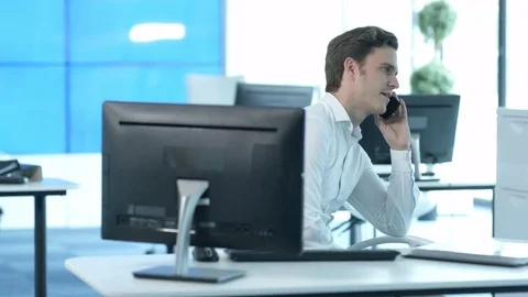 Young man taking cell phone call in office 스톡 동영상 80551852