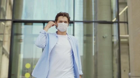 Young man taking off face mask outside Stock Footage 134574889