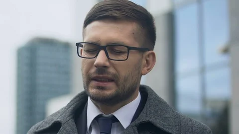 Young man taking off glasses and rubbing temples, suffering high blood pressure Видео 117222865