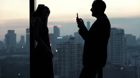 Young man taking photo of his pretty girlfriend standing close to the window dur Stock Footage 59123959