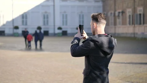Young man taking photograph with smartphone outdoor Stock Footage 100703285
