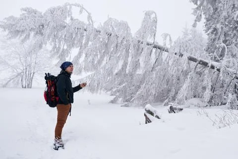 Young man taking photos of a snow covered winter landscape Stock Photos