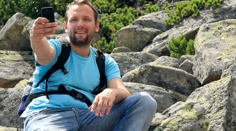 Young man taking picture with mobile phone in the mountains Stock Footage 7902570