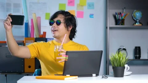 Young Man Taking Picture While Working on Summer Vacation Season at Office 4K Video stock 91468708
