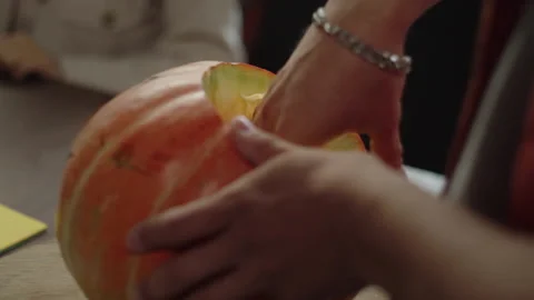 A young man is taking the pulp out of the pumpkin Stock Footage 170403235