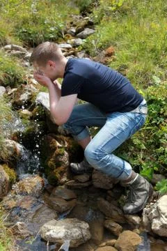 Young man taking a refreshment in the mountains Stock Photos