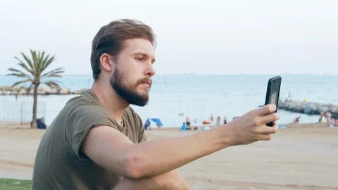 Young Man Taking Selfie on Beach with Smartphone Stock Footage 118928559