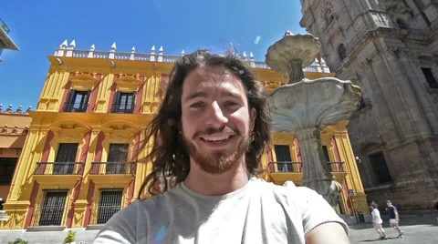 Young man taking a selfie in front of a monument Vidéo 63543180