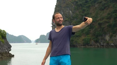 Young man taking selfie photo during cruise in Ha Long bay Stock Footage 163335583