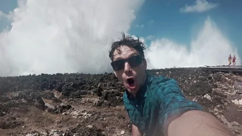 Young man taking a selfie, surprising about ocean water blow Stock-Footage 93098544