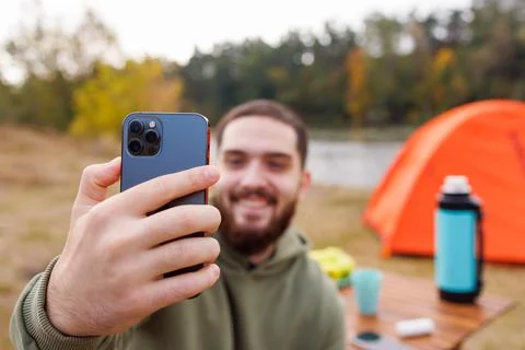 Young Man Taking a Selfie While Camping by the Lake Stock Photos