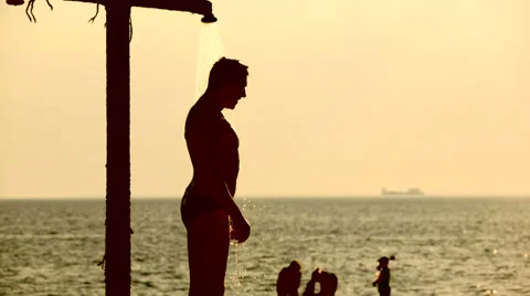 Young man taking a shower on the beach Stock-Footage 36548119
