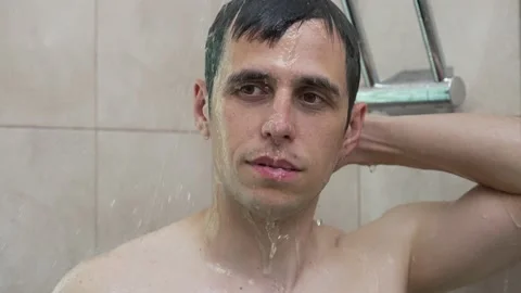Young man taking a shower Stock Footage 157585562